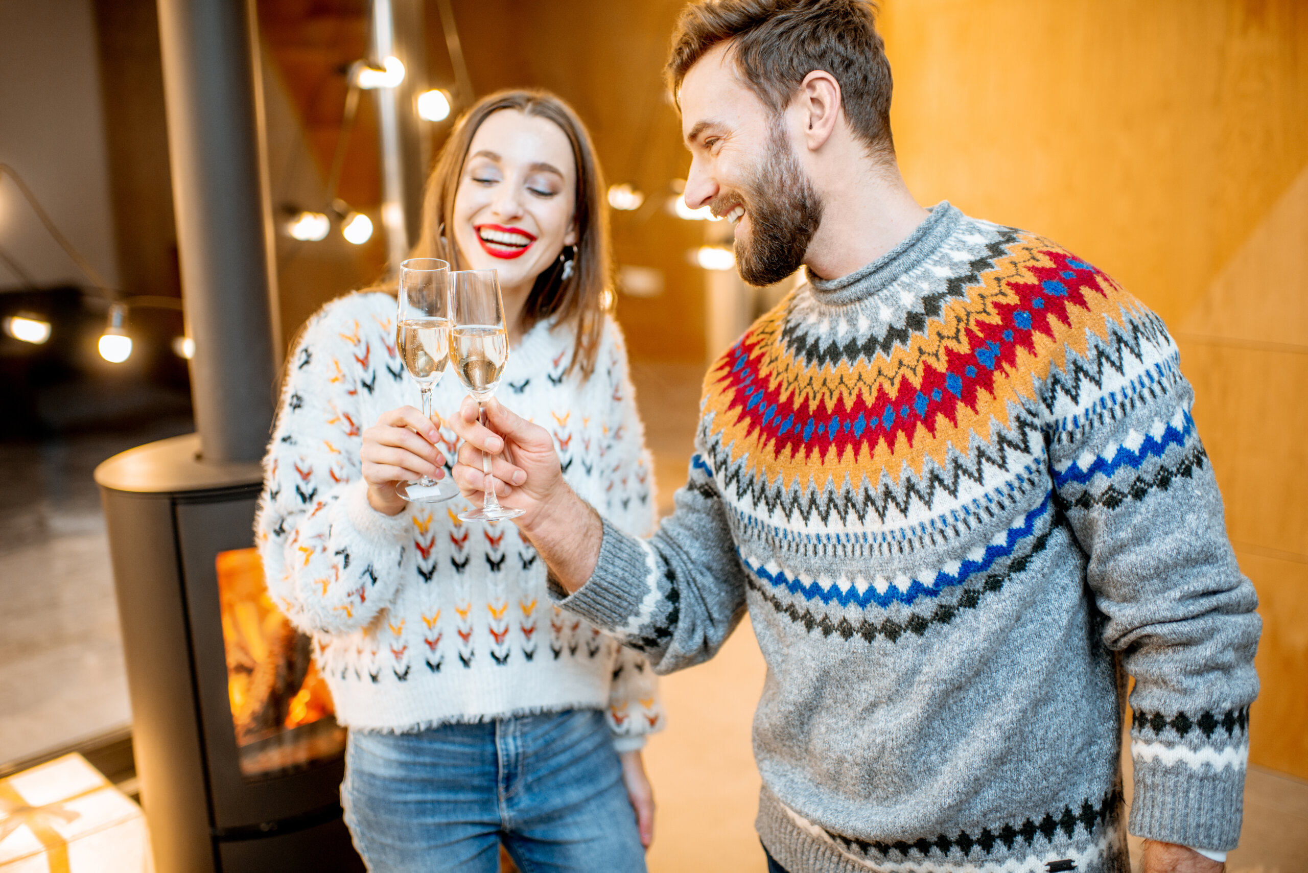 Couple celebrating winter holidays with wine indoors